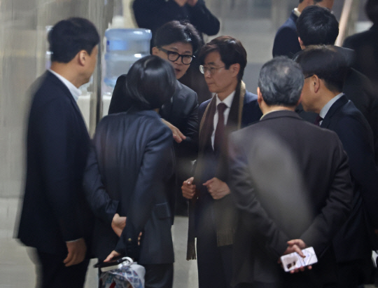 지난 12월7일 한동훈 국민의힘 대표가 7일 국회 국민의힘 의원총회 회의장 앞에서 조경태 의원과 대화하고 있다.<연합뉴스 사진>